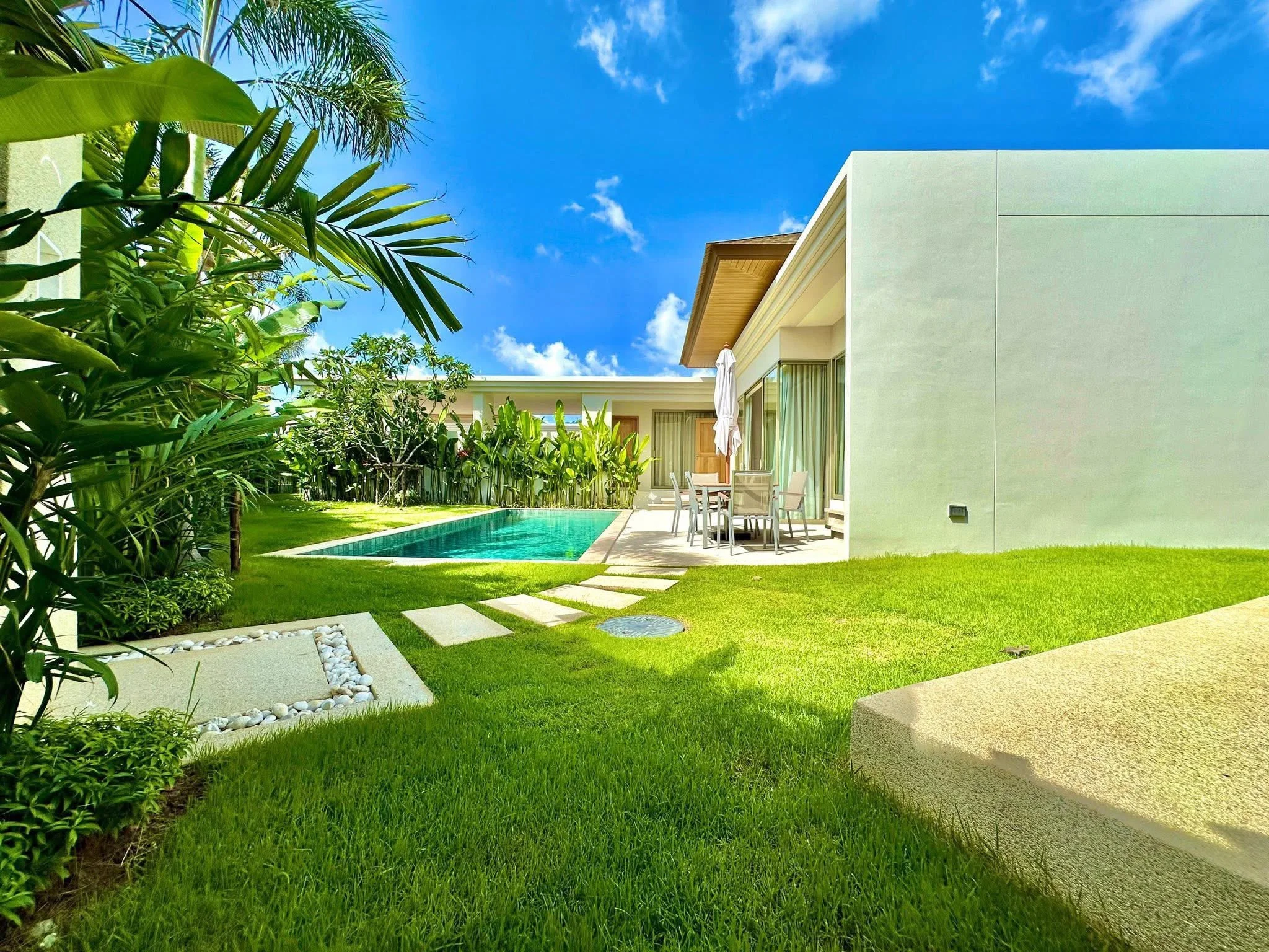 Jardín paisajístico con piscina privada y terraza de villa, Cherngtalay