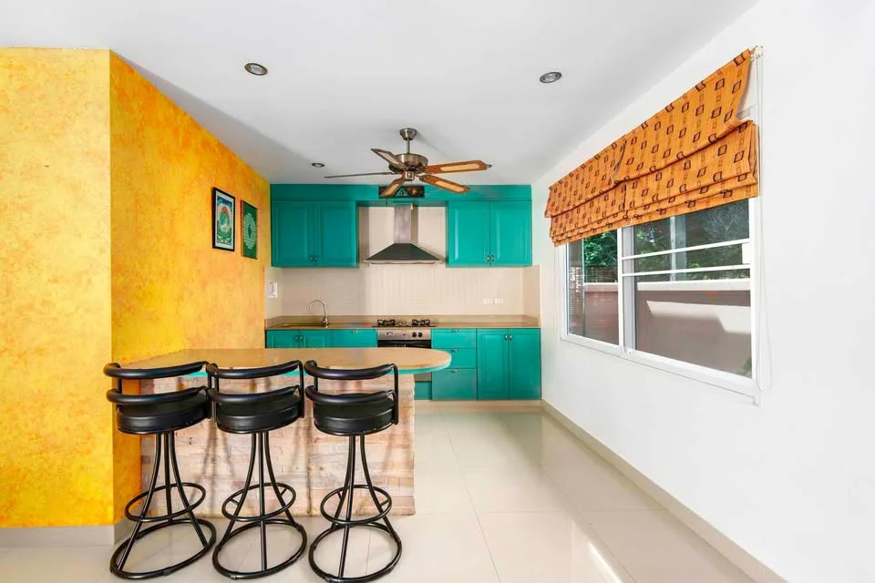 Intérieur de cuisine avec armoires turquoise et bar petit-déjeuner dans villa 2 chambres, Rawai